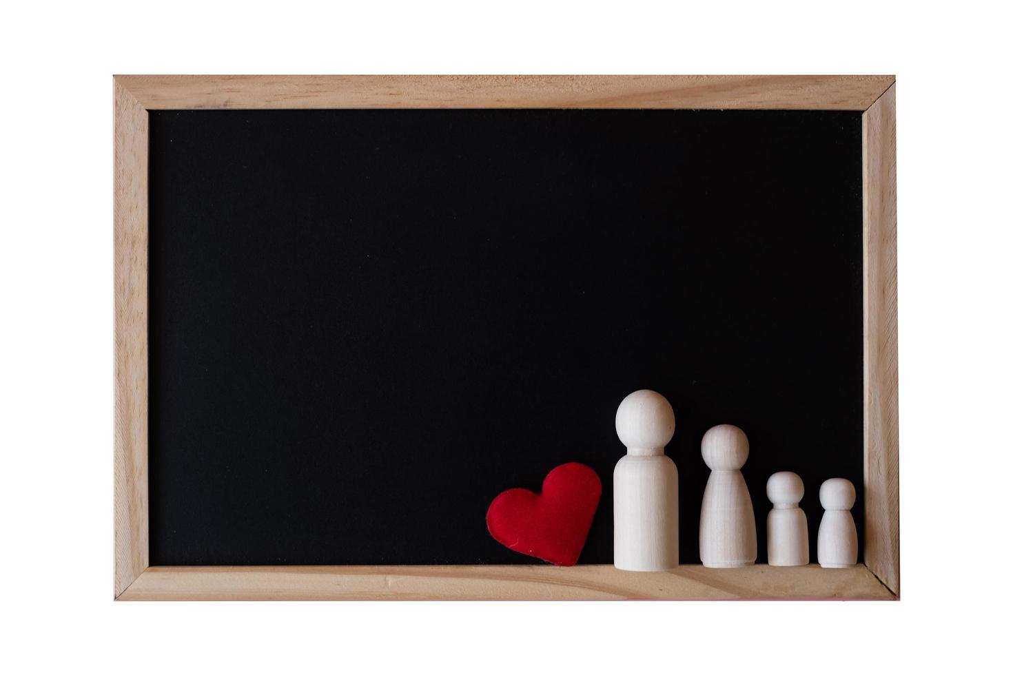 Wooden figurines of family father, mother and children on the black board on white background.  copy space for text. photo