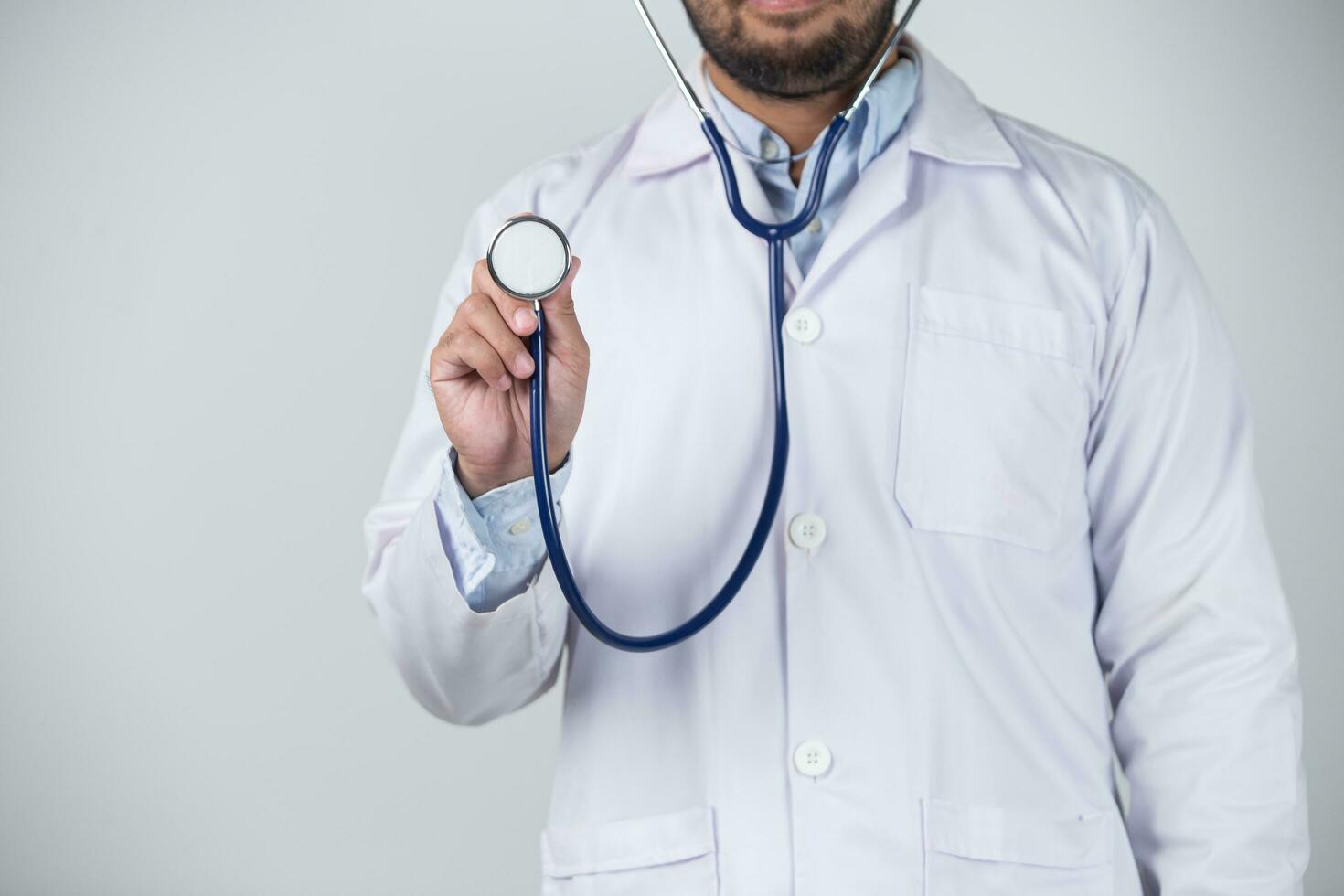 male doctor is holding stethoscope into the camera photo