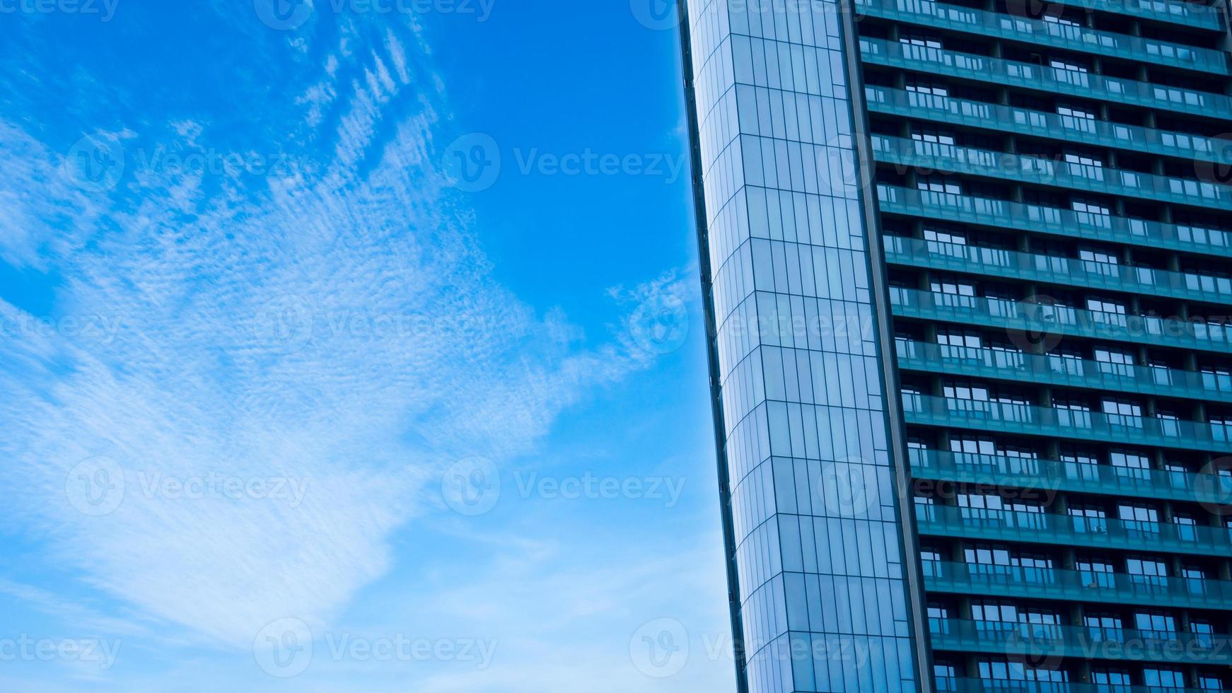 Glass building with balcony with blue sky background,Abstract part of modern architecture, glass and concrete walls photo