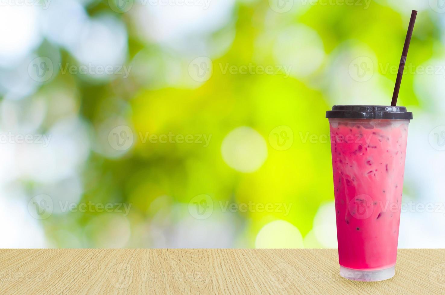 Ice tea,iced pink milk tea on green nature background ,Summer drinks with ice photo