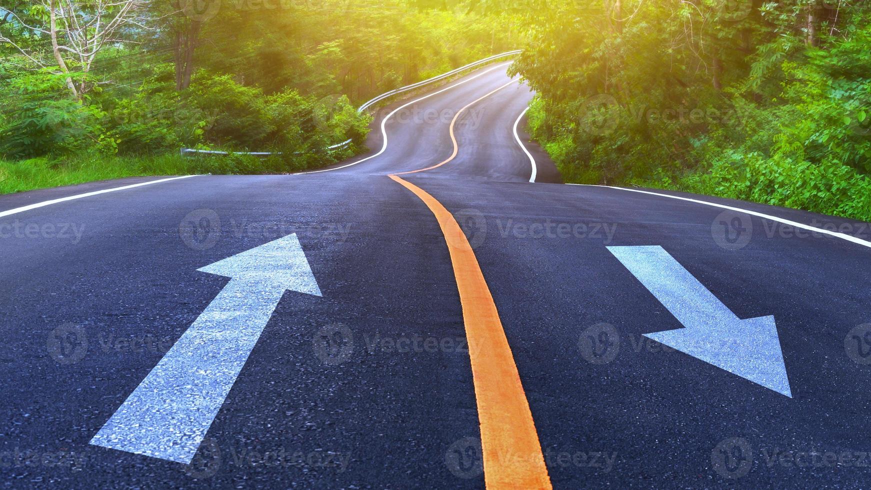 Countryside road and yellow line with white arrow with trees on both sides, Curve of the road, two way road photo