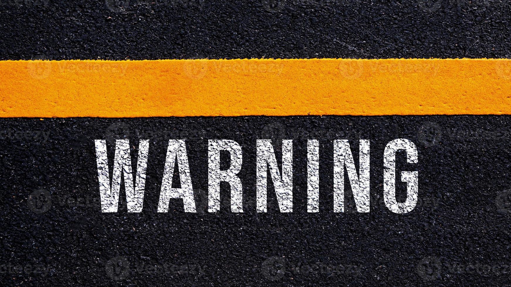 Warning written and yellow line on the road in middle of the asphalt road, Warning word on street. photo