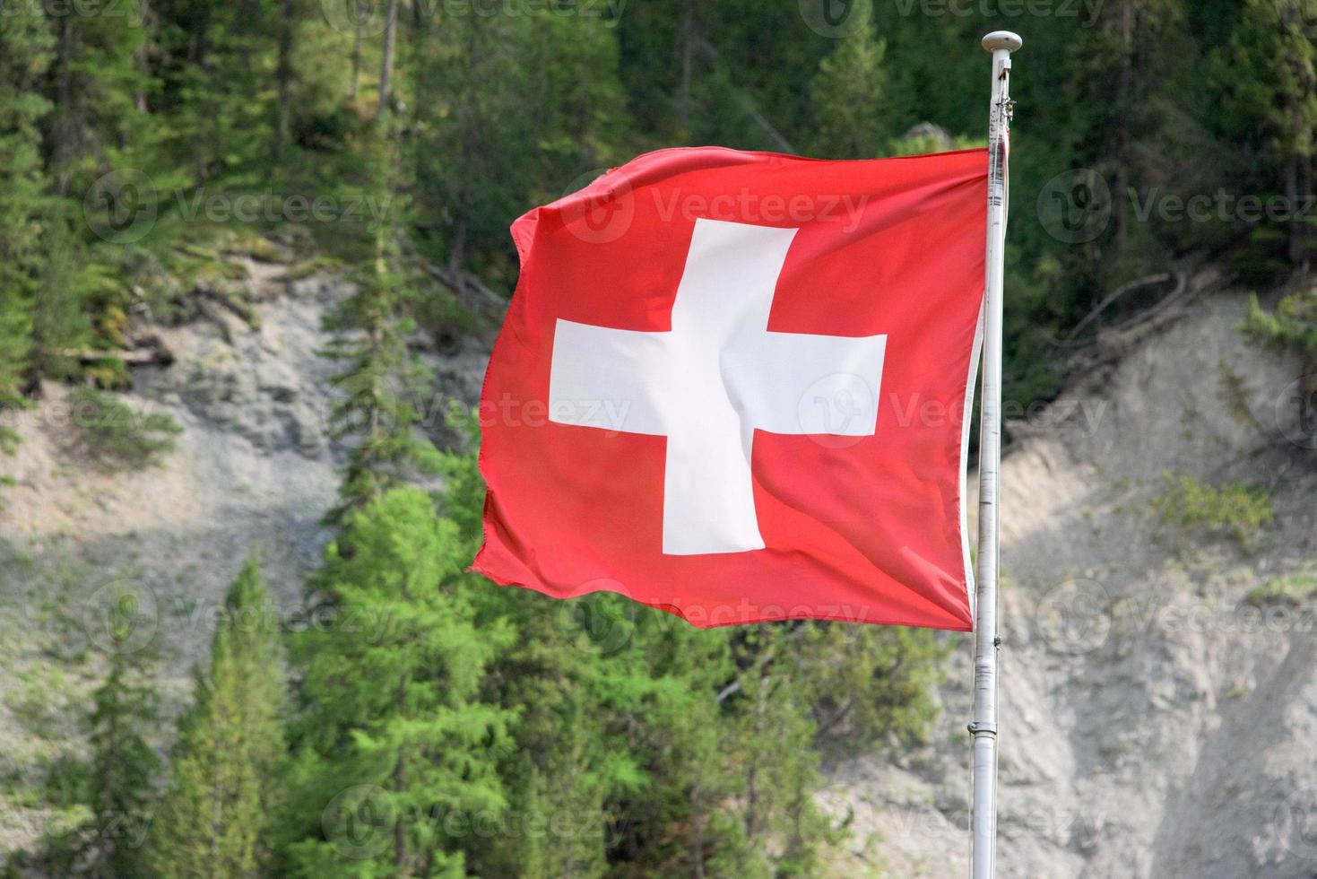 Swiss Waving flag on mountain background photo