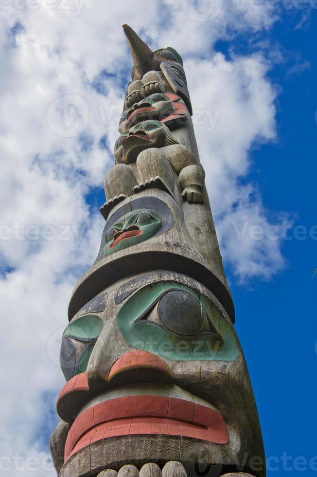 A totem wood pole in the blue cloudy background photo