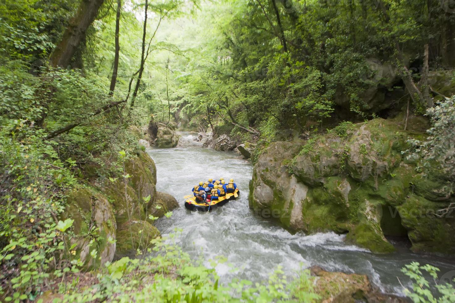 Teamwork of People Rafting on a creek in yellow boat photo