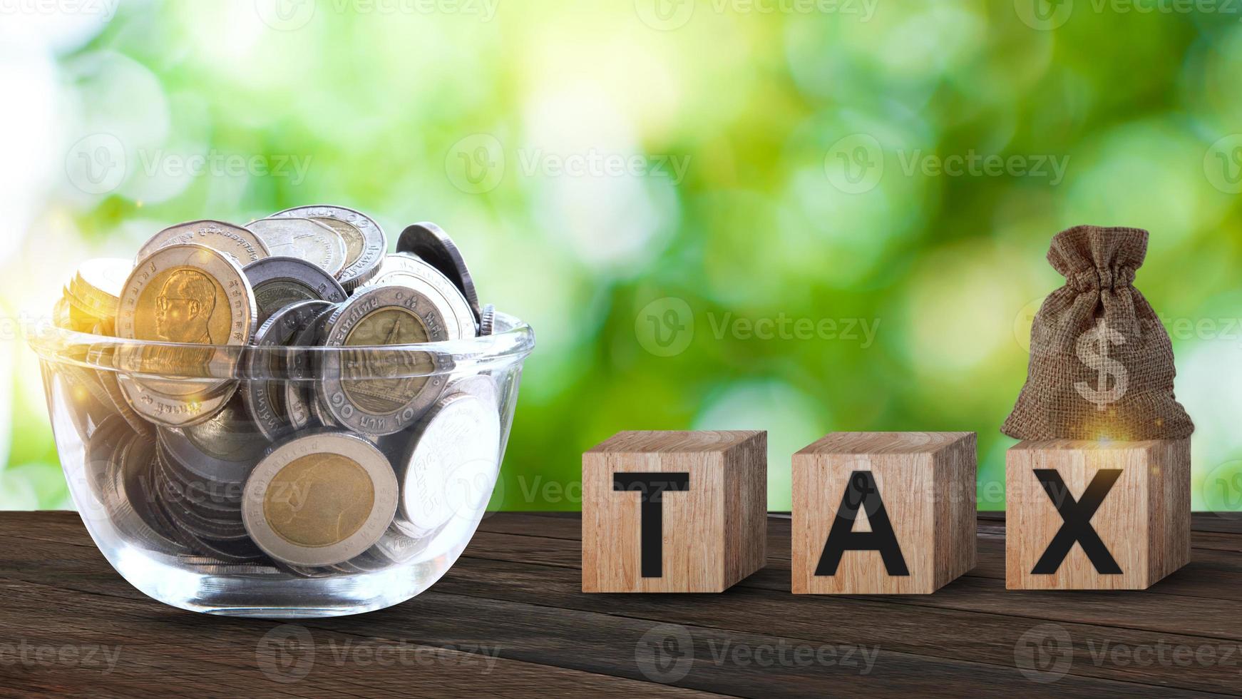 Wooden blocks with the words Tax and US dollar money bag and coins, Taxes payment concept. Tax evasion. Taxation. Business and finance. photo