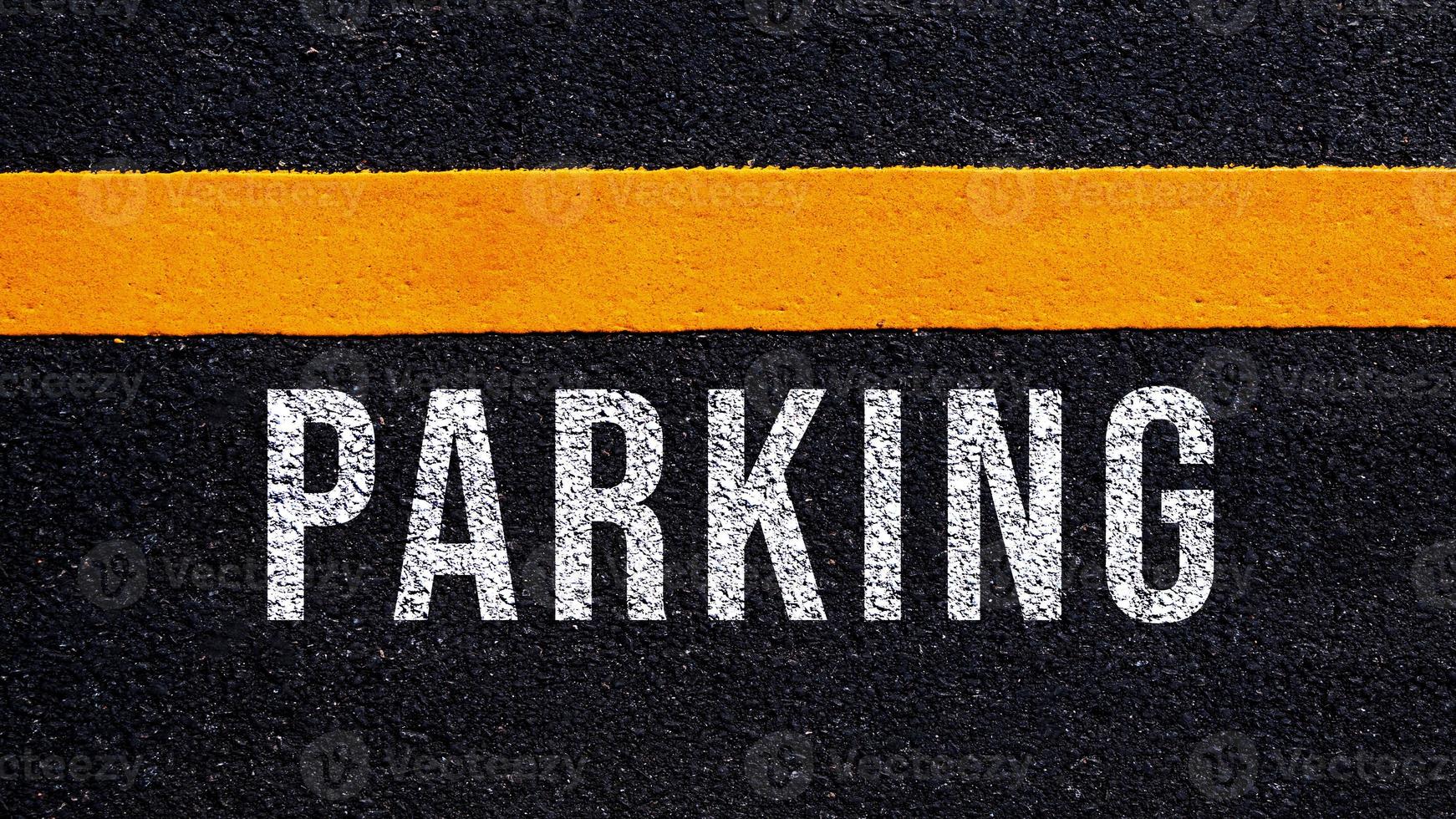 estacionamiento escrito y amarillo línea en el la carretera en medio de el asfalto camino, estacionamiento palabra en calle foto