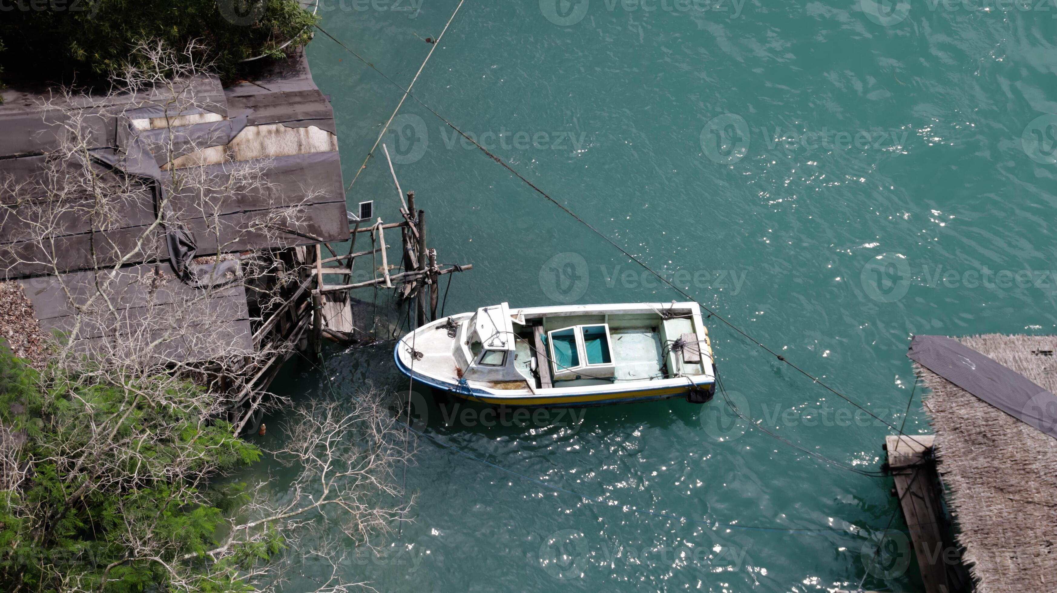 A white boat docking near floating village. 20340425 Stock Photo at