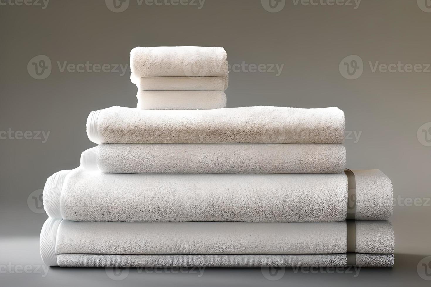 Clean various size white folded towel nice and tidy stack each other for fitness, bath, swimming, massage and spa marketing background and design material isolated on grey background. photo