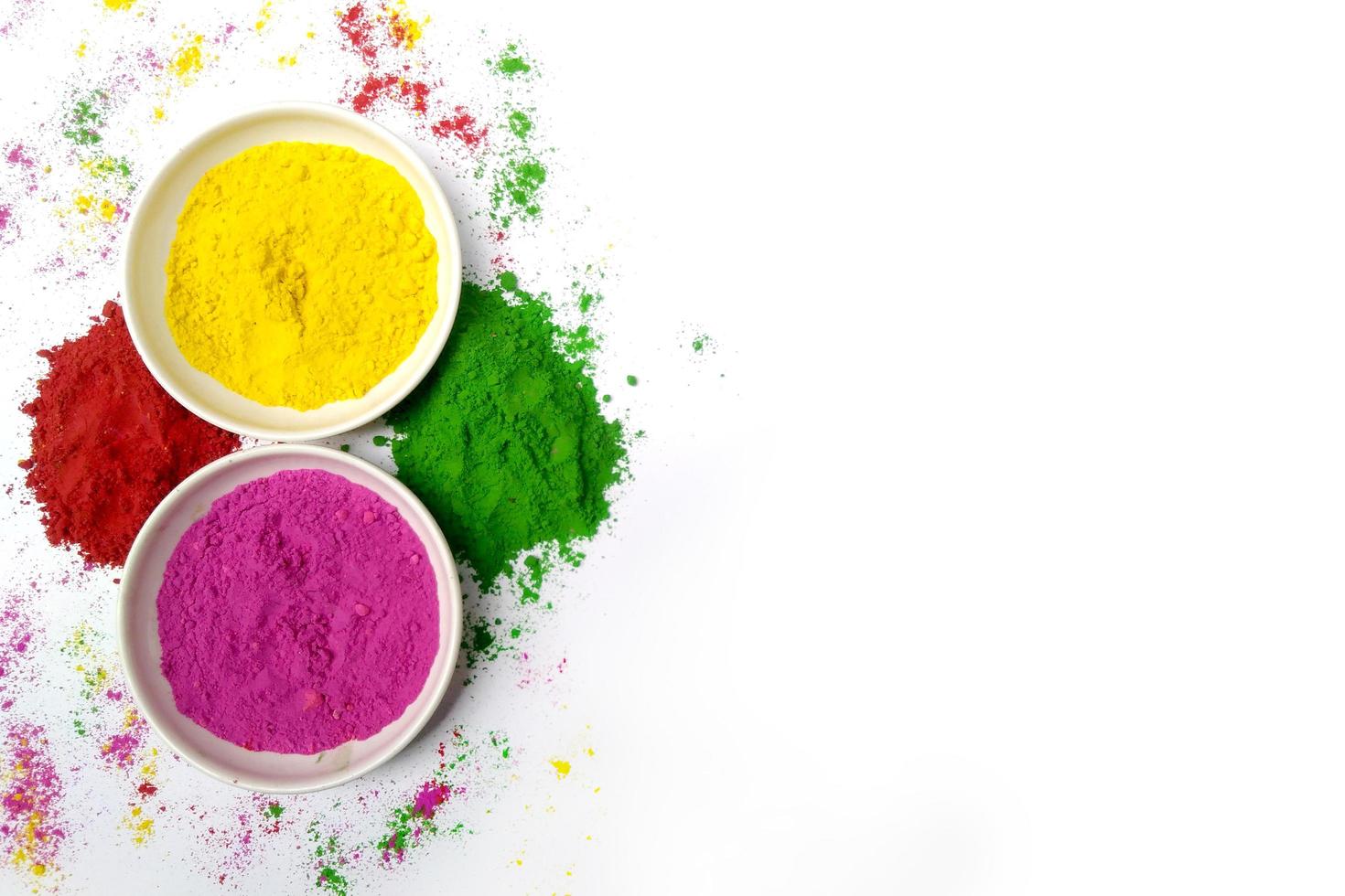 happy holi indian festival, top view colours powder in bowls with white background photo