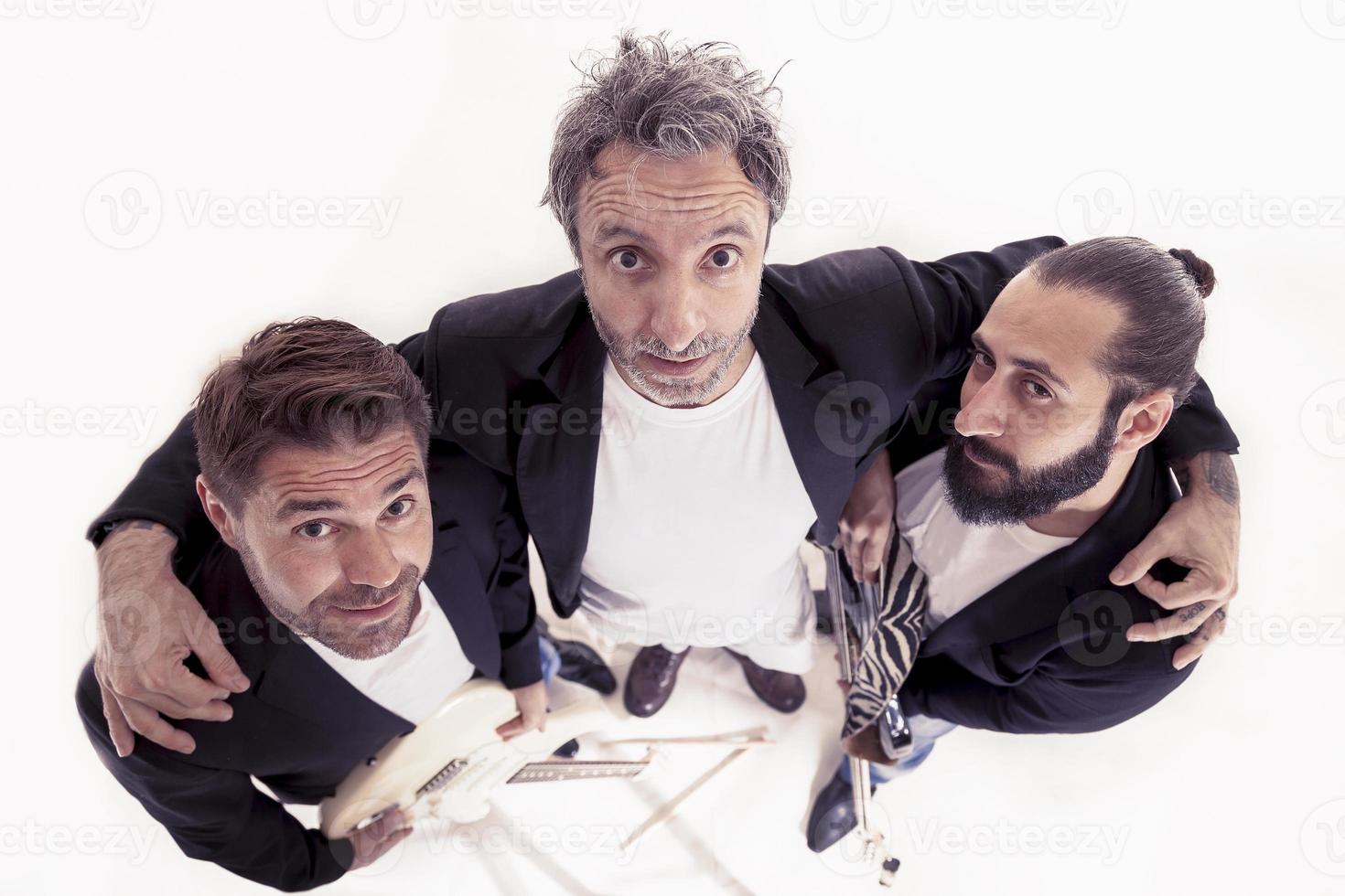 portrait of rock band trio embraced in the studio photo