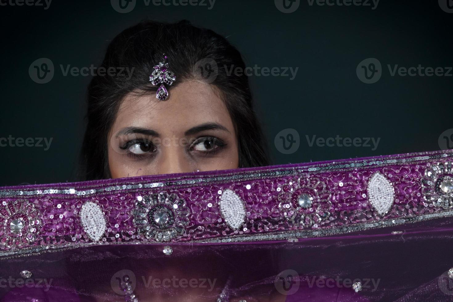 Portrait of smiling beautiful indian girl wearing traditional purple clothes photo