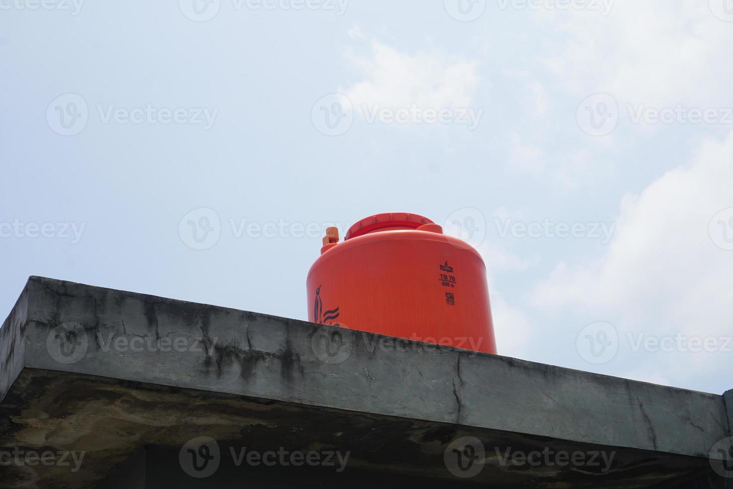 big orange water reservoir on the roof of the house. photo