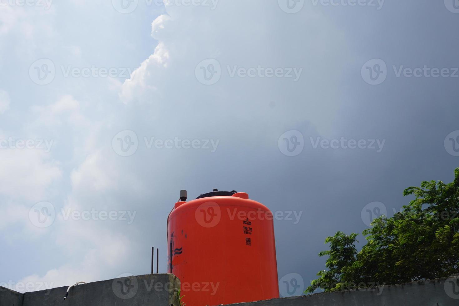 grande naranja agua reservorio en el techo de el casa. foto