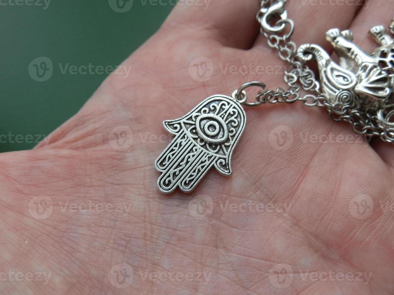 Religious metal symbol medallion in hand photo