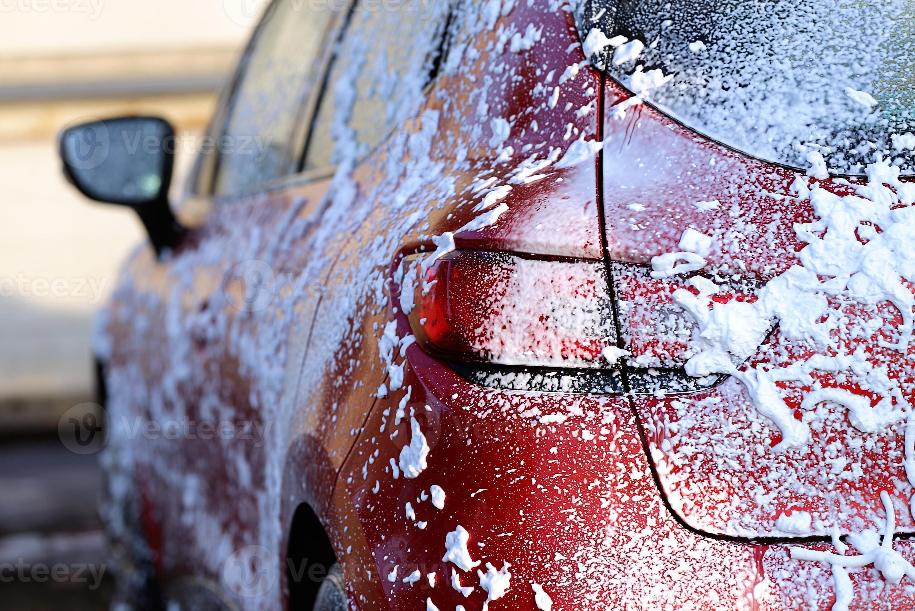 Worker washing car with sponge on a car wash, Manual car wash with