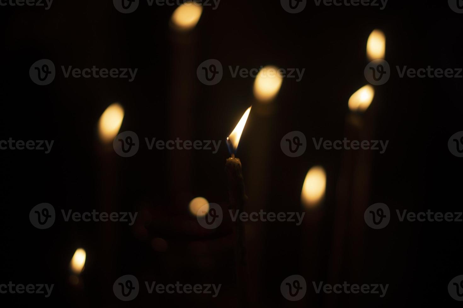 Candles burn in dark. Candle lights. Flames on black background