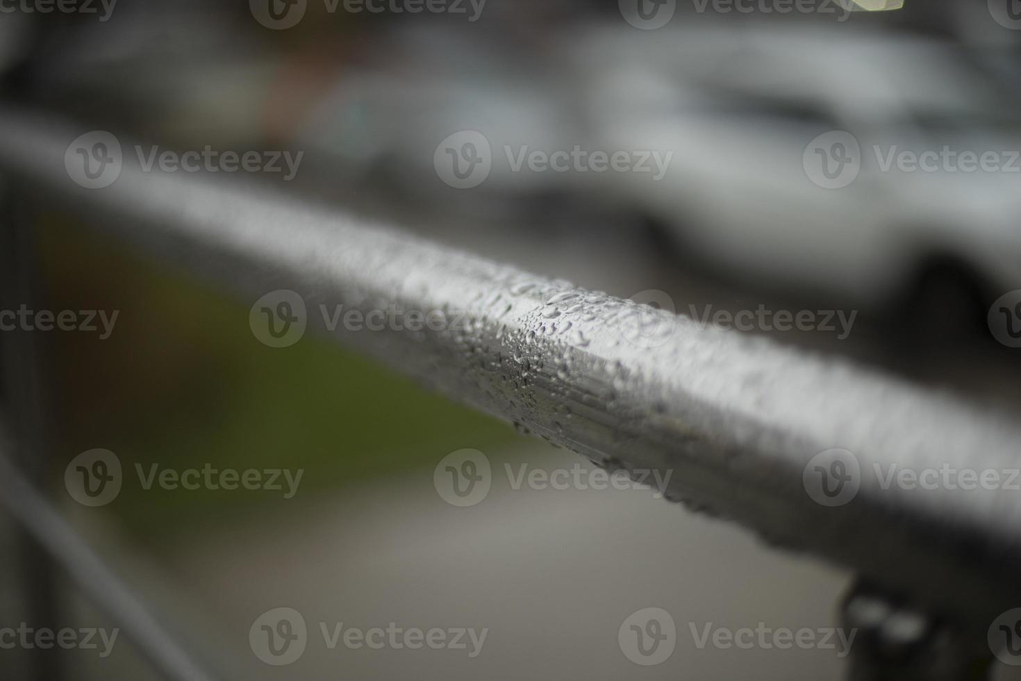 Wet handrail. Steel pipe in water droplets. Silver steel pole. photo