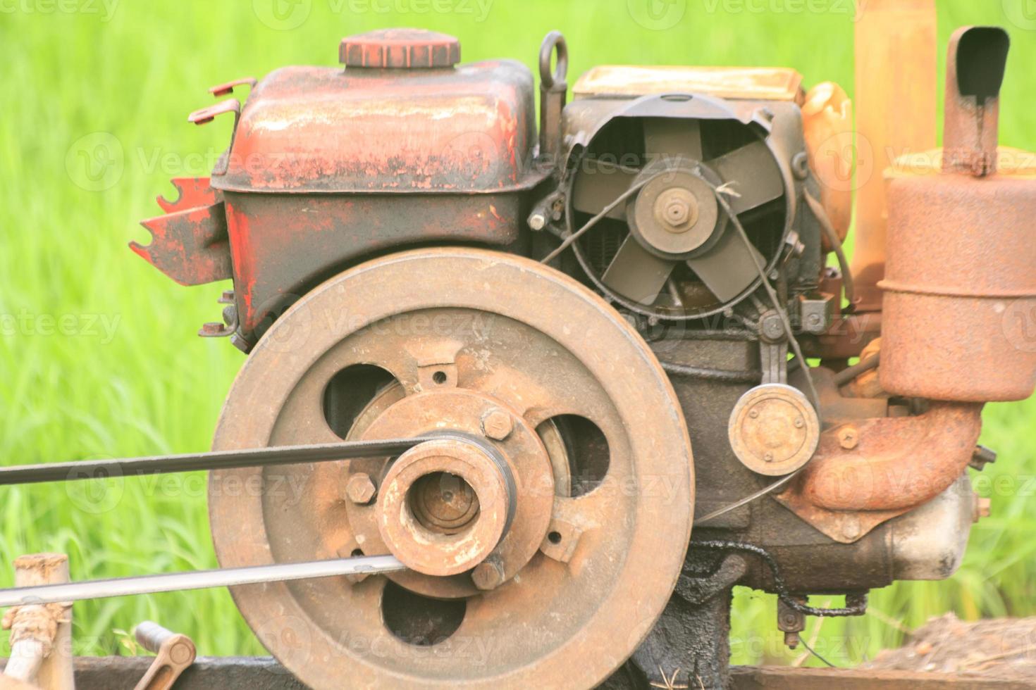 The old red water pump that is spinning at full power to pump water into the rice fields of farmers during the rice growing season in rural Thailand. photo