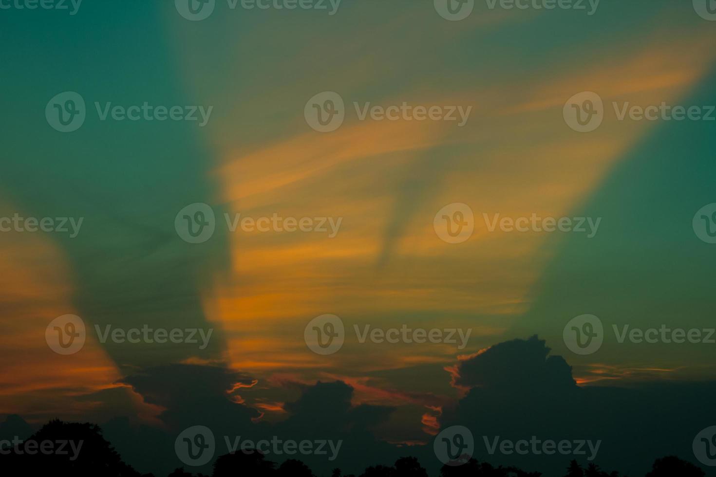 atmosphere in the evening sky as the sun sets - beams - of the sun and clouds create beautiful colors and many colors, creating a warm and romantic atmosphere on a summer evening. photo