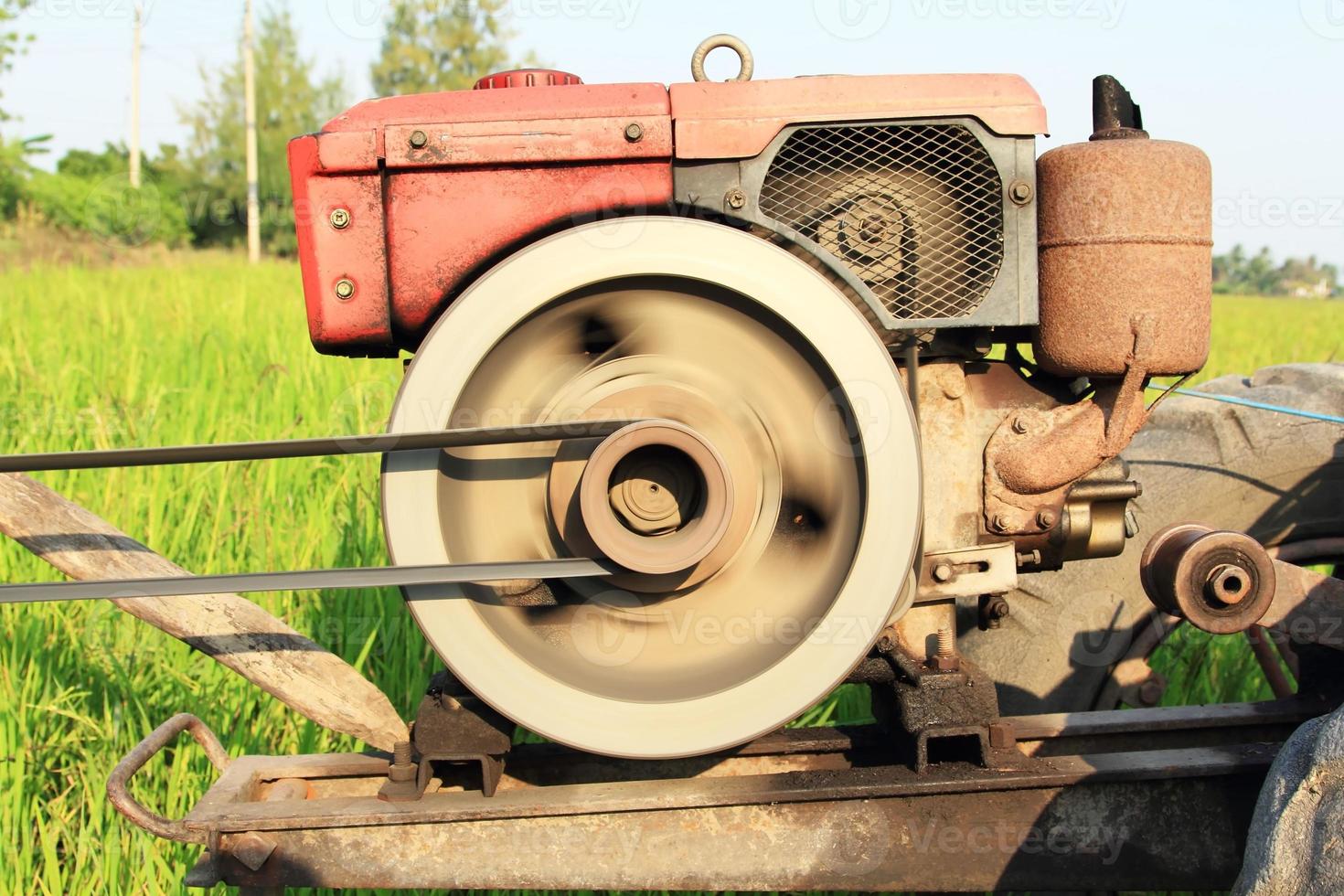 The old red water pump that is spinning at full power to pump water into the rice fields of farmers during the rice growing season in rural Thailand. photo