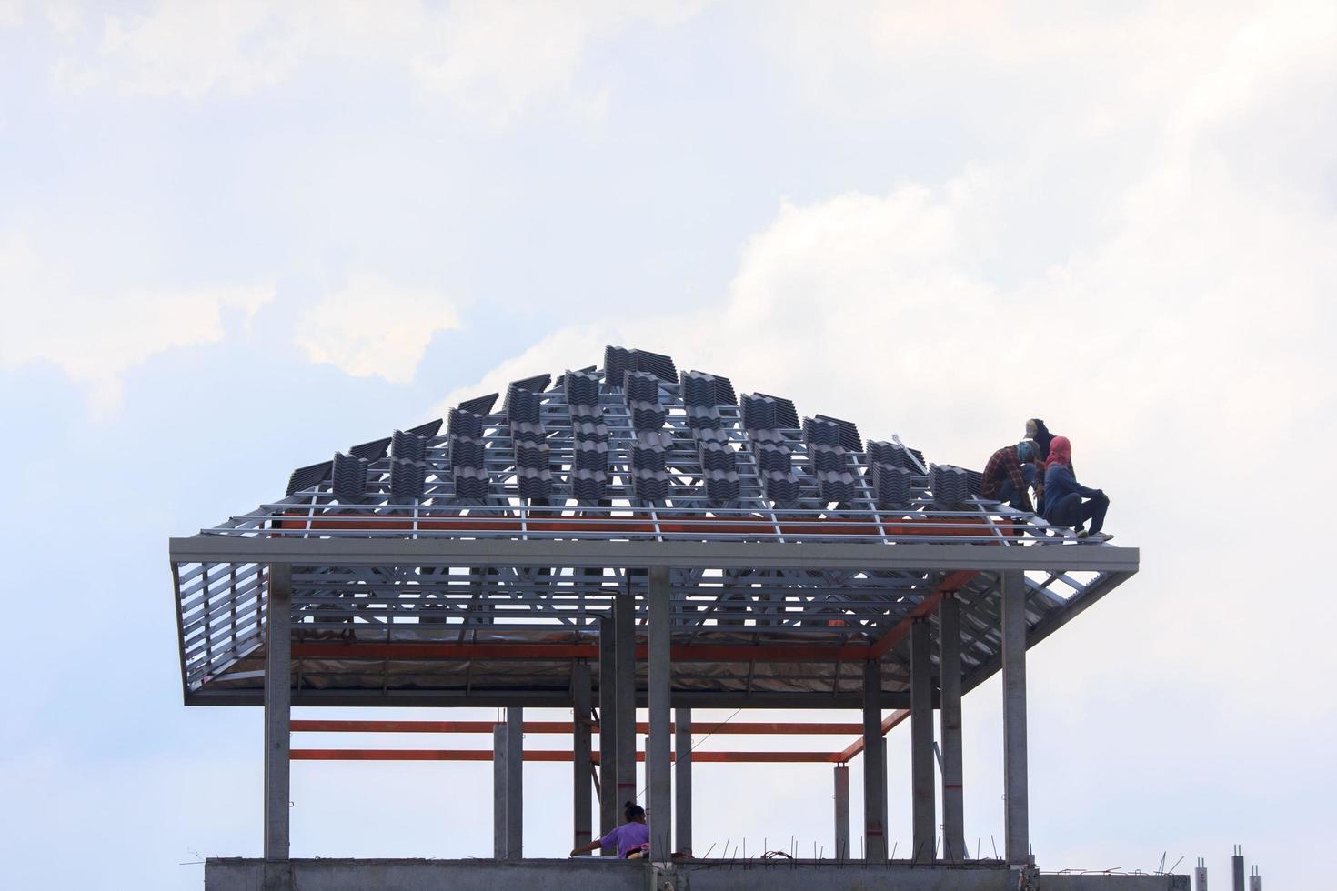 construction of a house with a thick steel frame and roofing tiles for sun and rain protection by skilled craftsmen who work at heights requires precision and extreme caution - Spanish style - photo