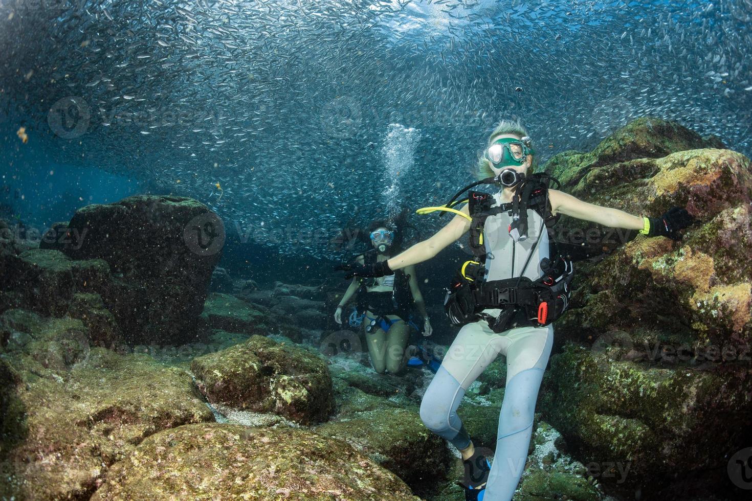 beautiful girls looking at you while swimming underwater photo