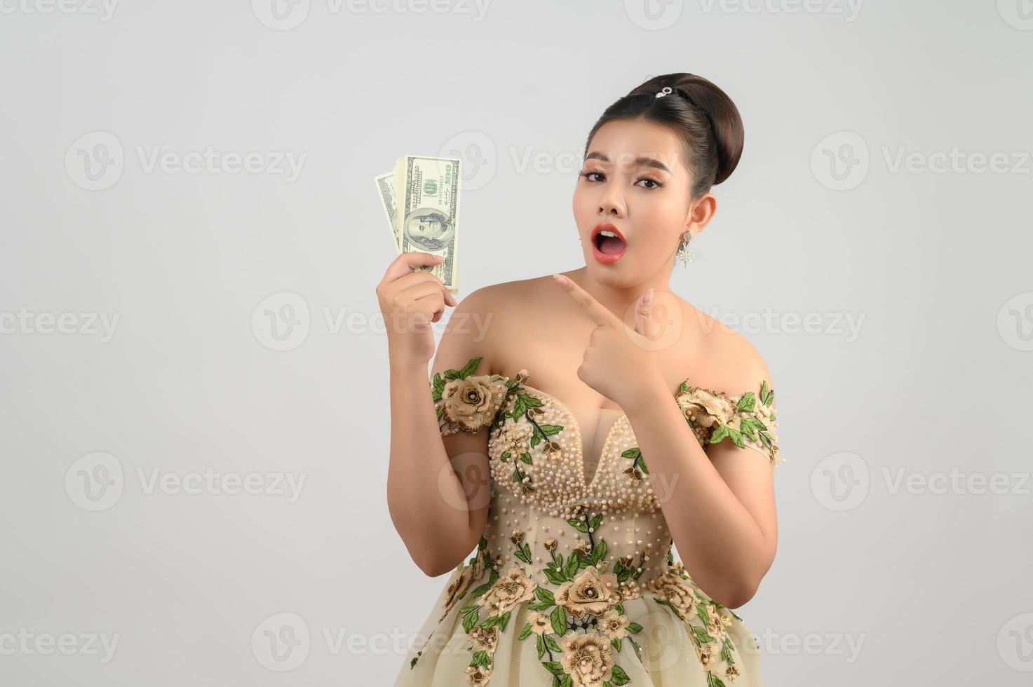 Young asian beautiful bride holding dollar bills in hand photo