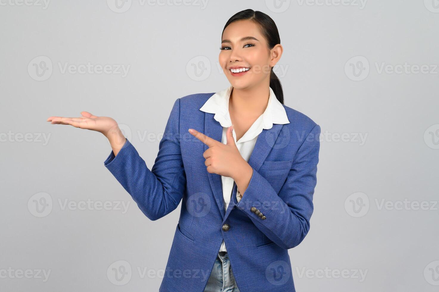 Young beautiful woman in formal clothing for officer showing product on palm photo