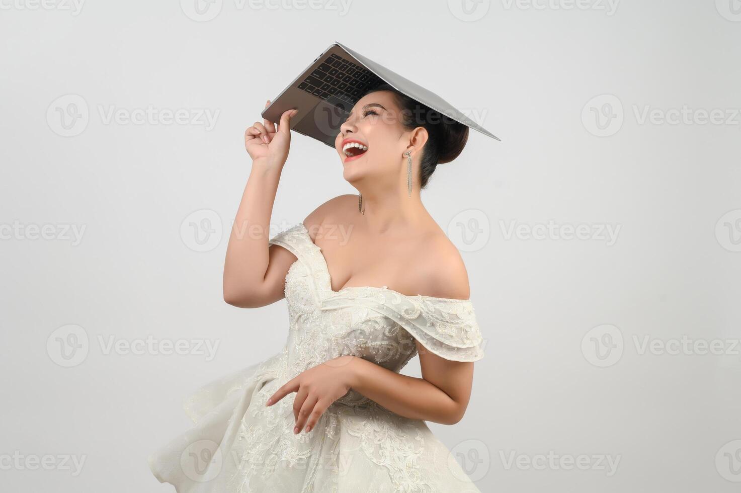 Young asian beautiful bride pose with laptop computer in hand photo