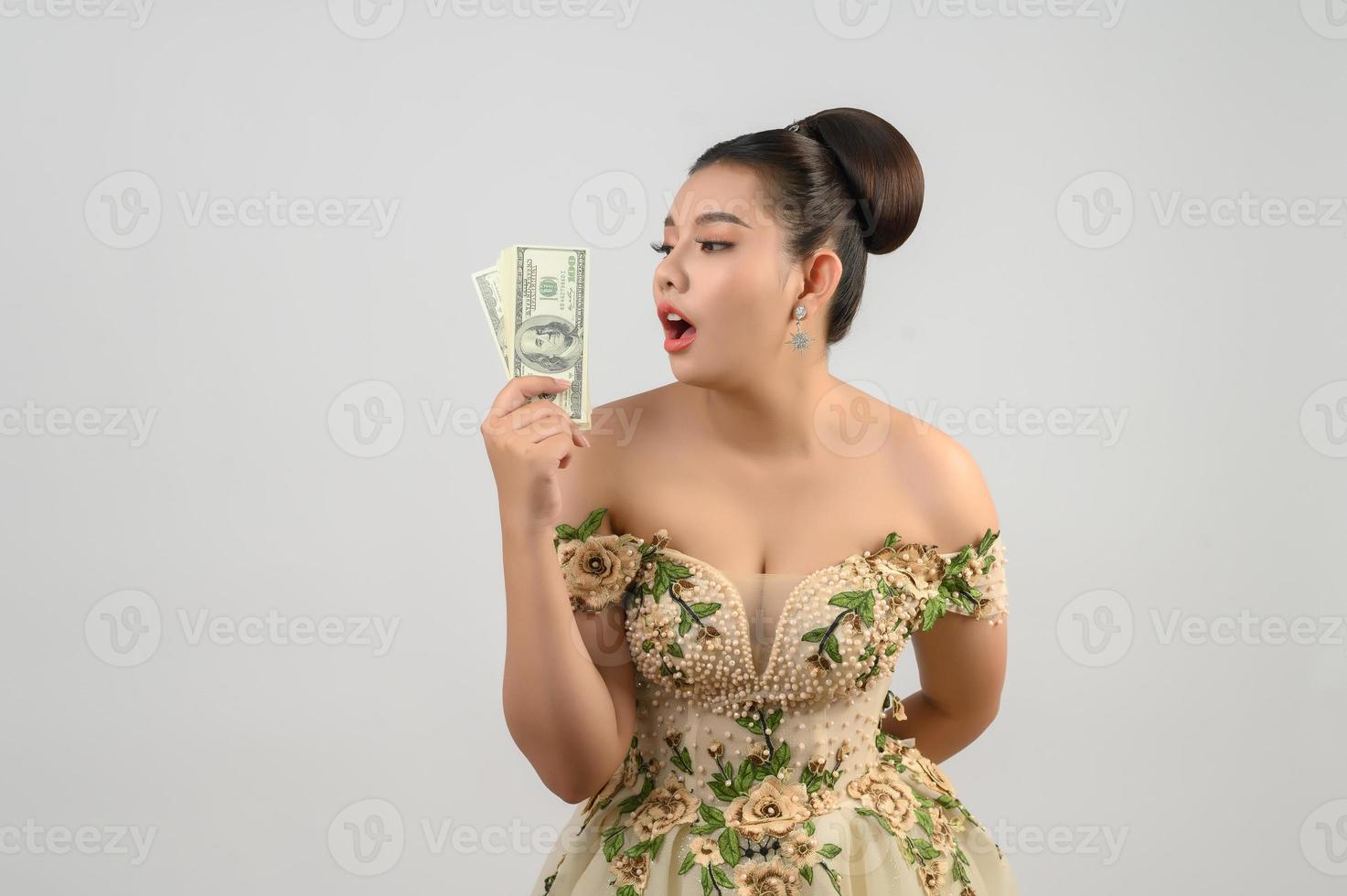 joven novia asiática hermosa con billetes de dólar en la mano foto
