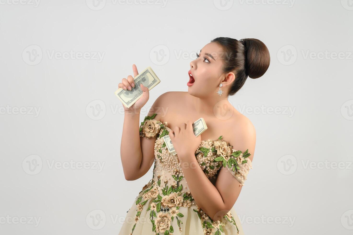 Young asian beautiful bride holding dollar bills in hand photo