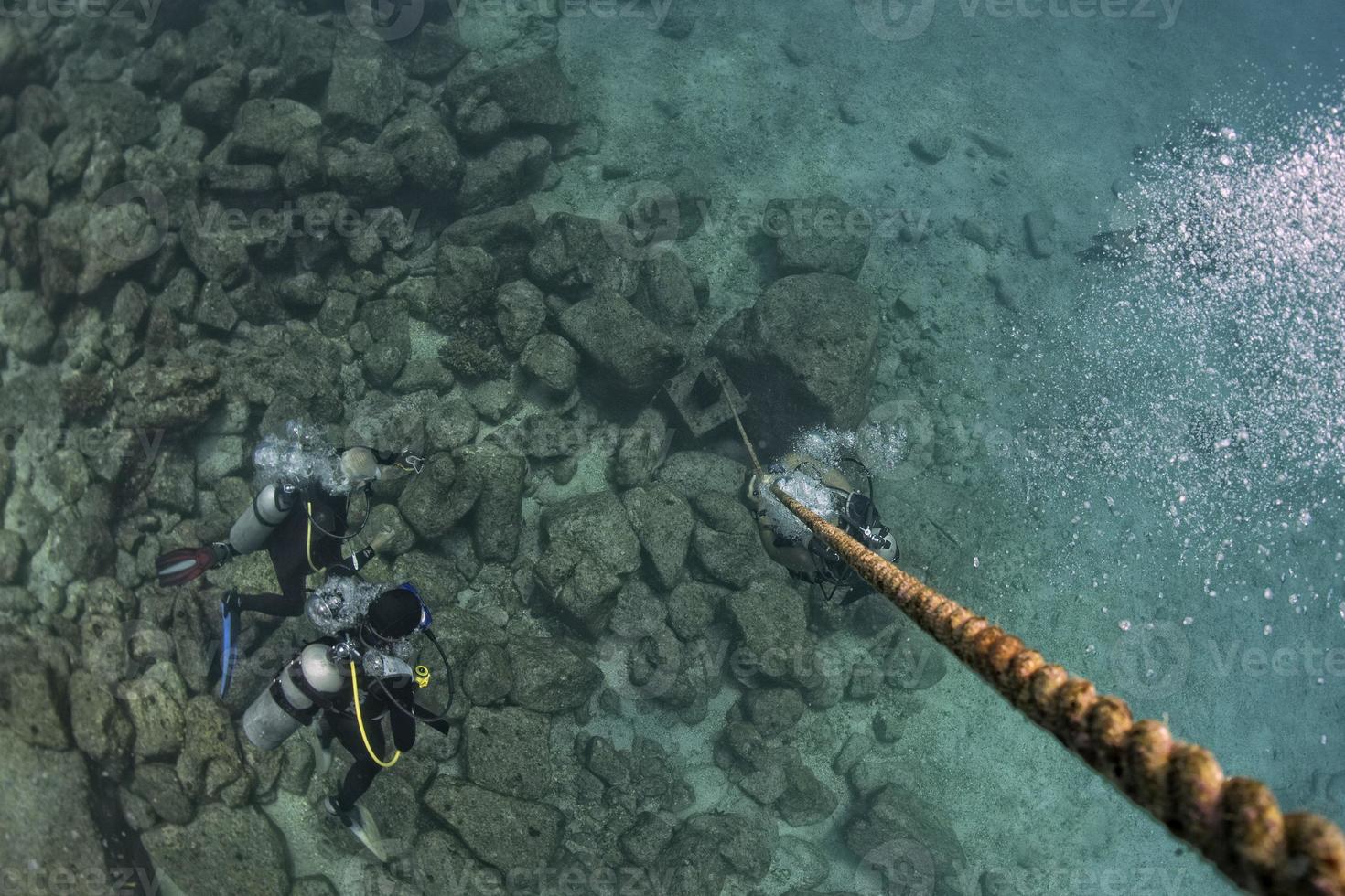 diver bubbles near boat rope underwater photo