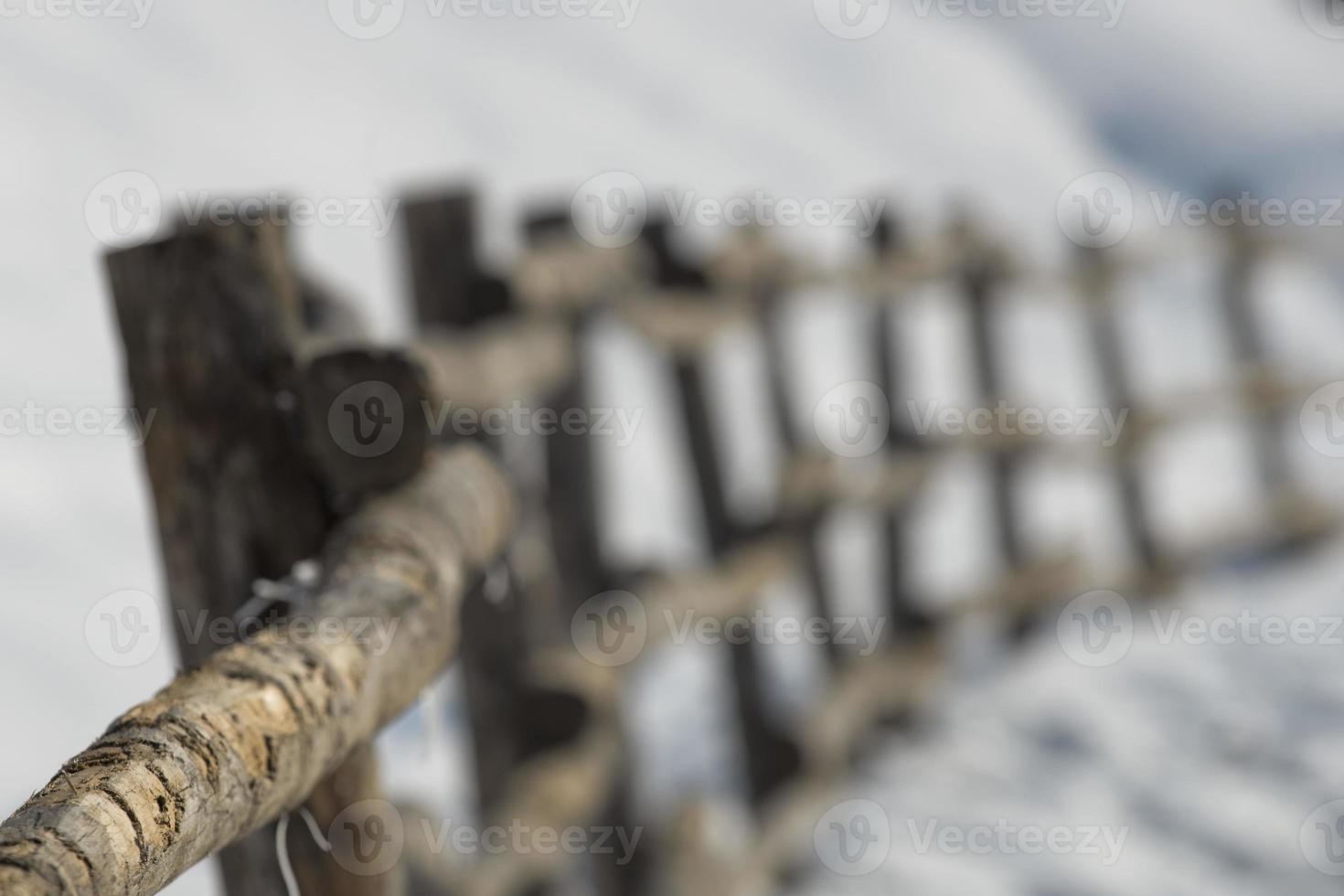 A wood fence over white snow background in winter time photo