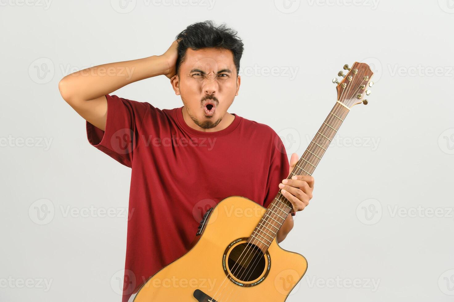 Portrait of Young Asian man in red t-shirt with an acoustic guitar isolated on white background photo