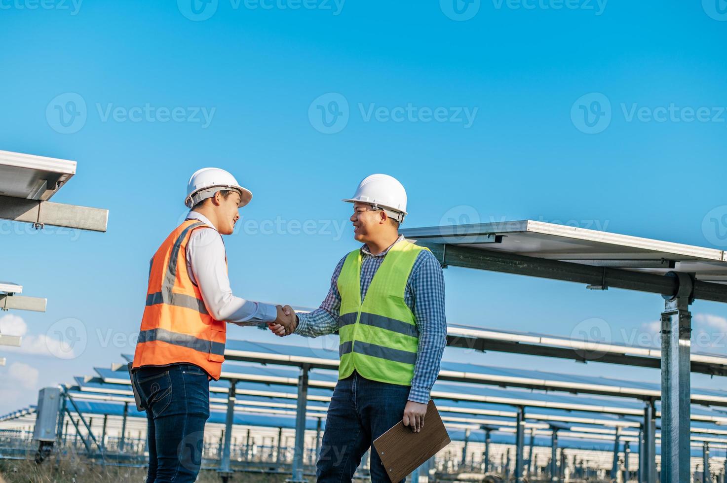 Two engineers are shaking hands at solar farm photo