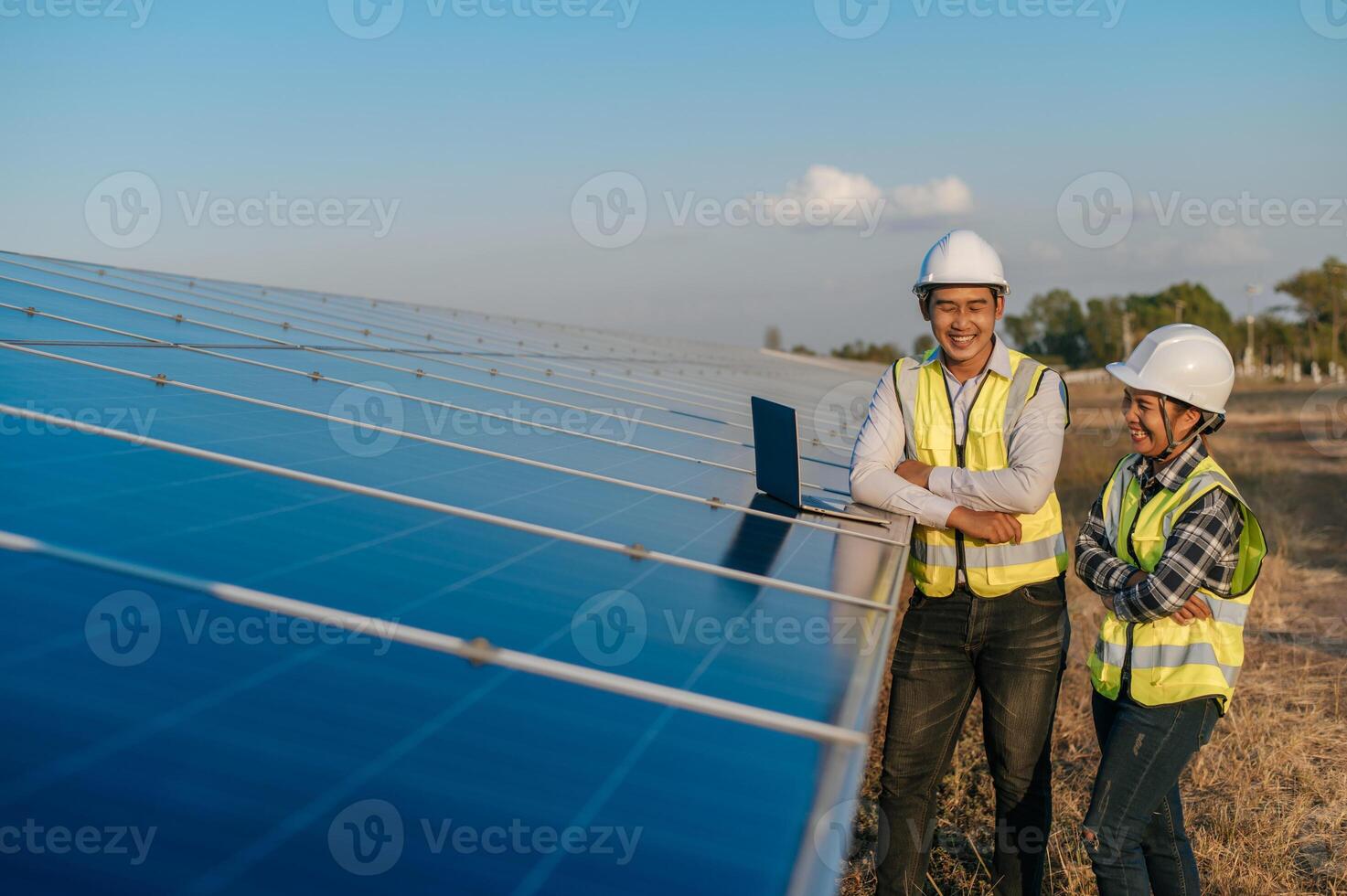 Young engineer and female owner discussing at solar farm photo