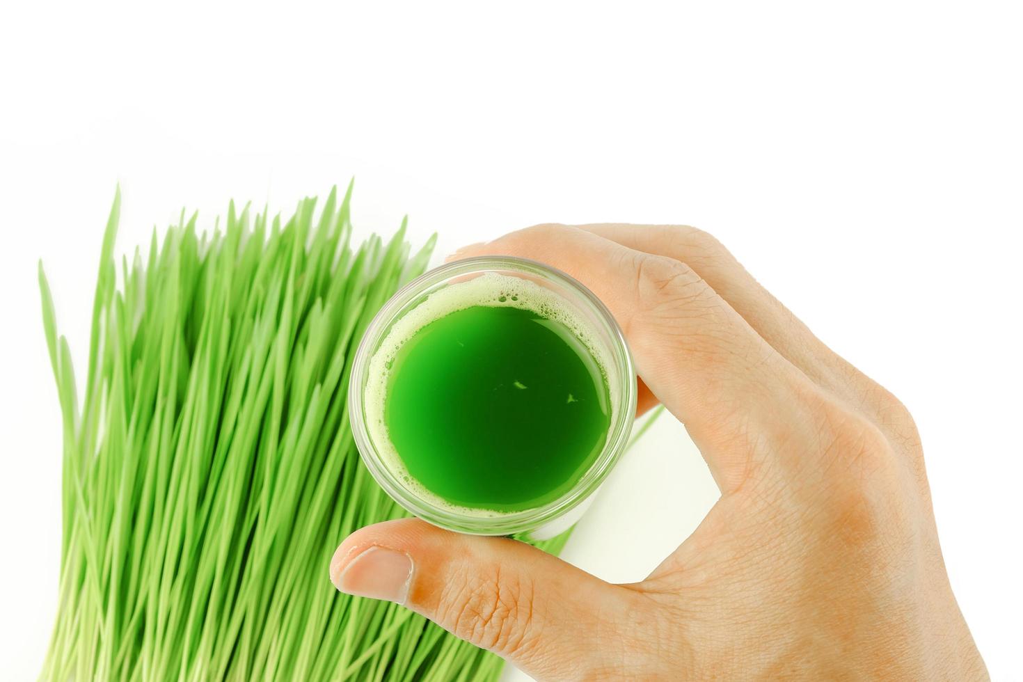 man hold shot of wheat grass juice to drinking photo