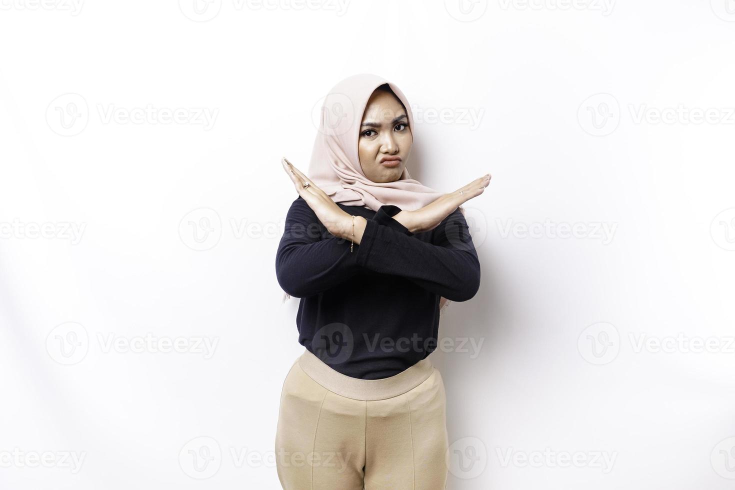 Beautiful Asian Muslim woman wearing a hijab with hand gesture pose rejection or prohibition with copy space photo