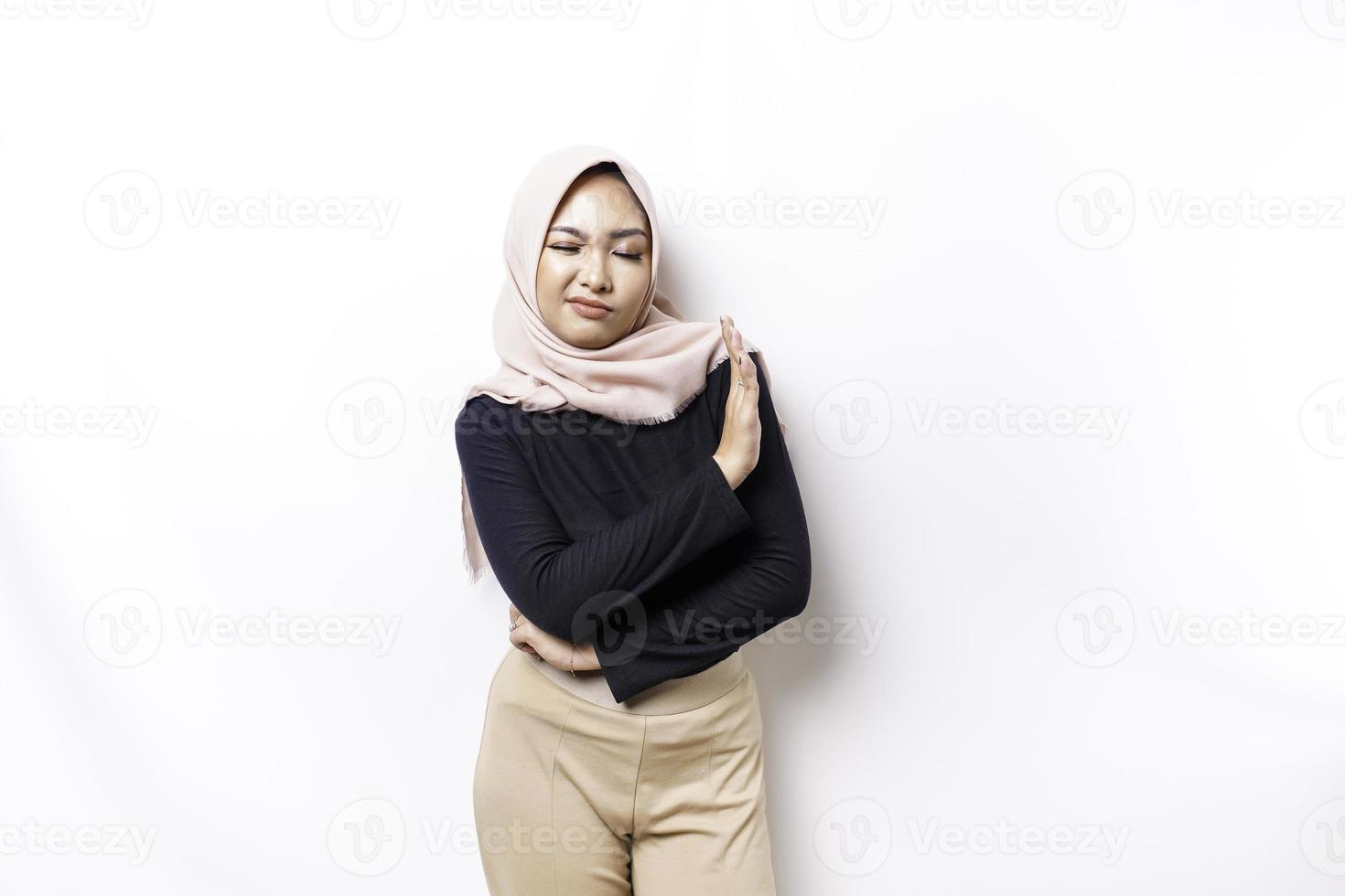 Beautiful Asian Muslim woman wearing a hijab with hand gesture pose rejection or prohibition with copy space photo