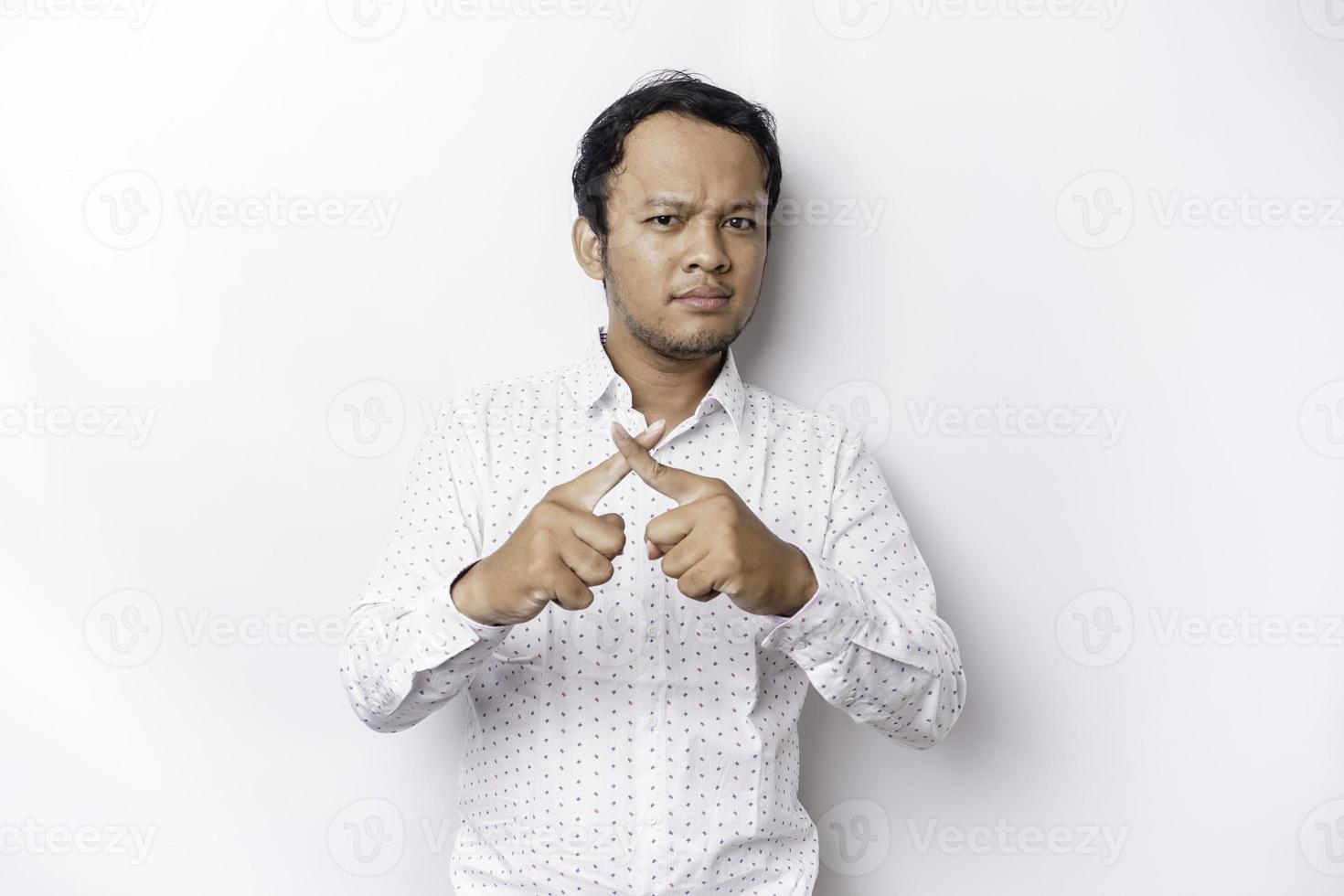 Handsome Asian man wearing white shirt with hand gesture pose rejection or prohibition with copy space photo