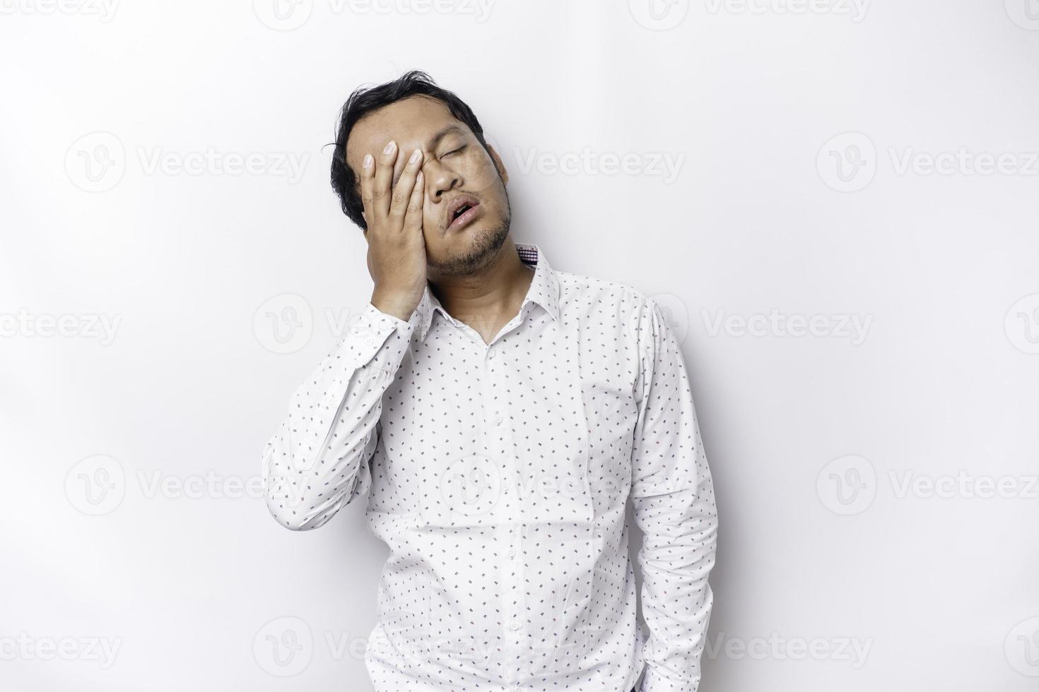 A portrait of an Asian man wearing a white shirt isolated by white background looks depressed photo