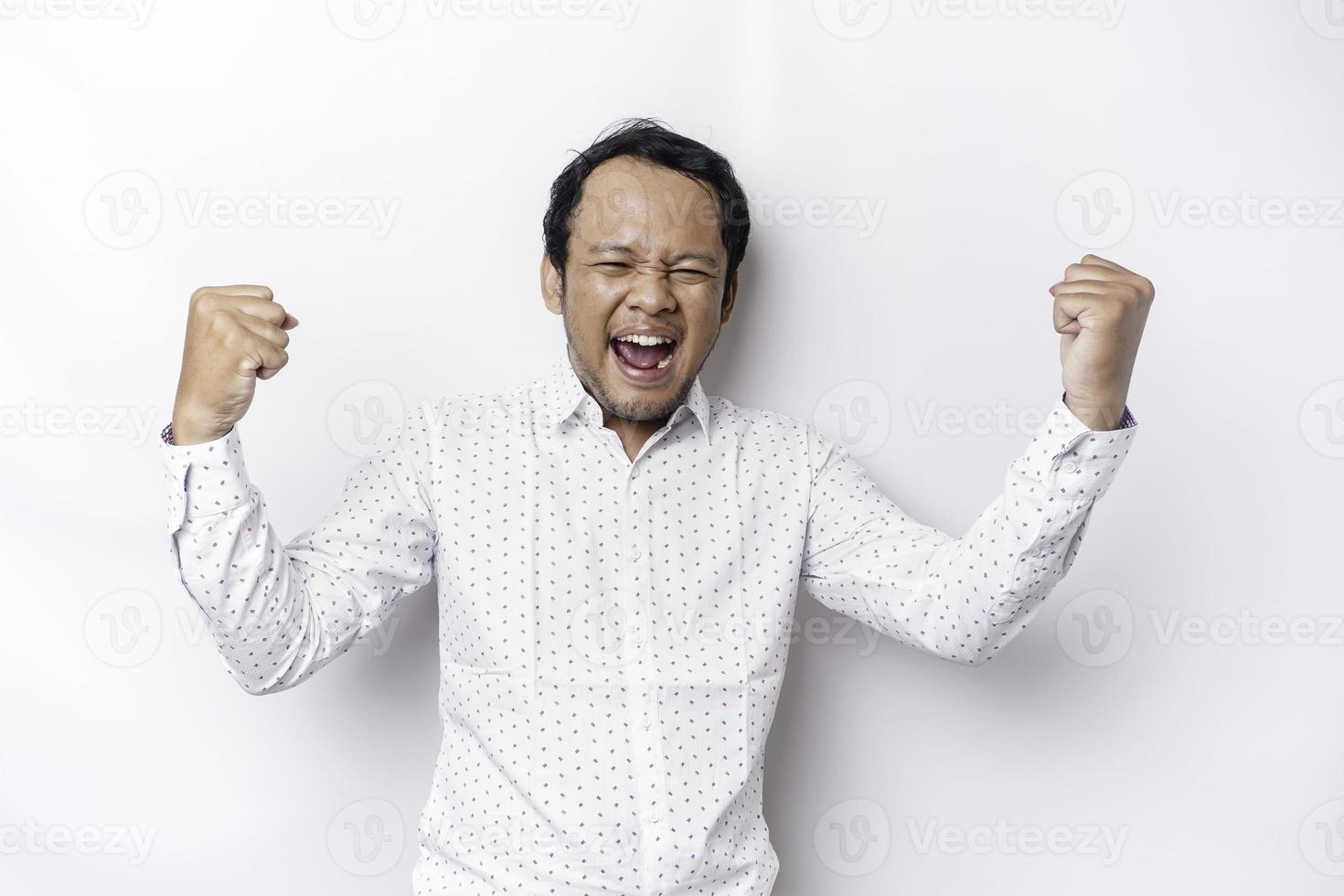 A young Asian man with a happy successful expression wearing white shirt isolated by white background photo