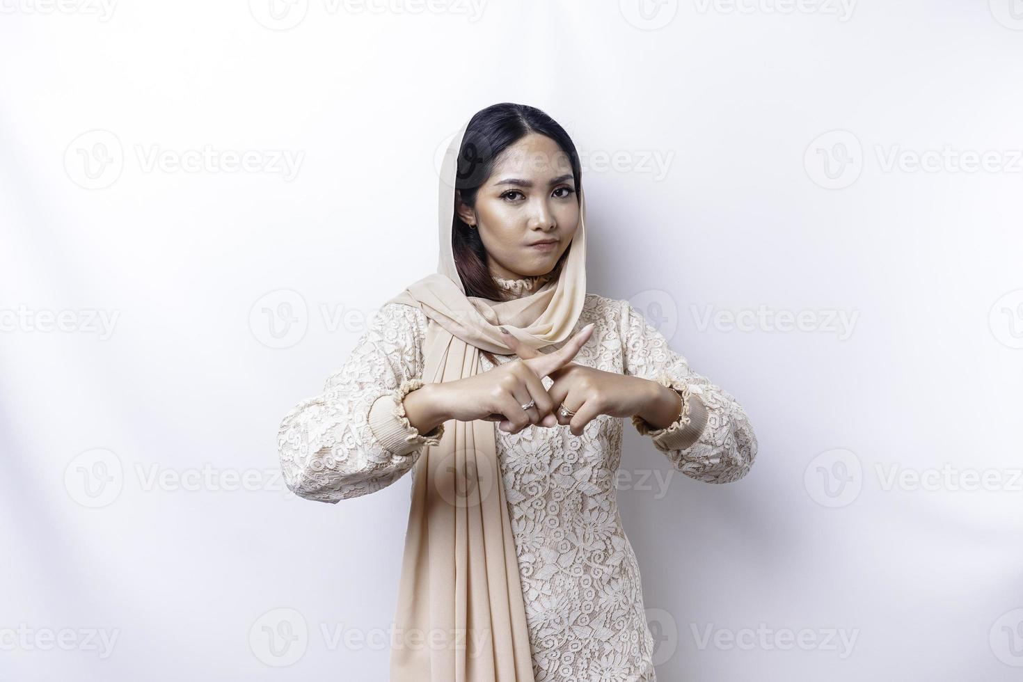 Beautiful Asian Muslim woman wearing a hijab with hand gesture pose rejection or prohibition with copy space photo