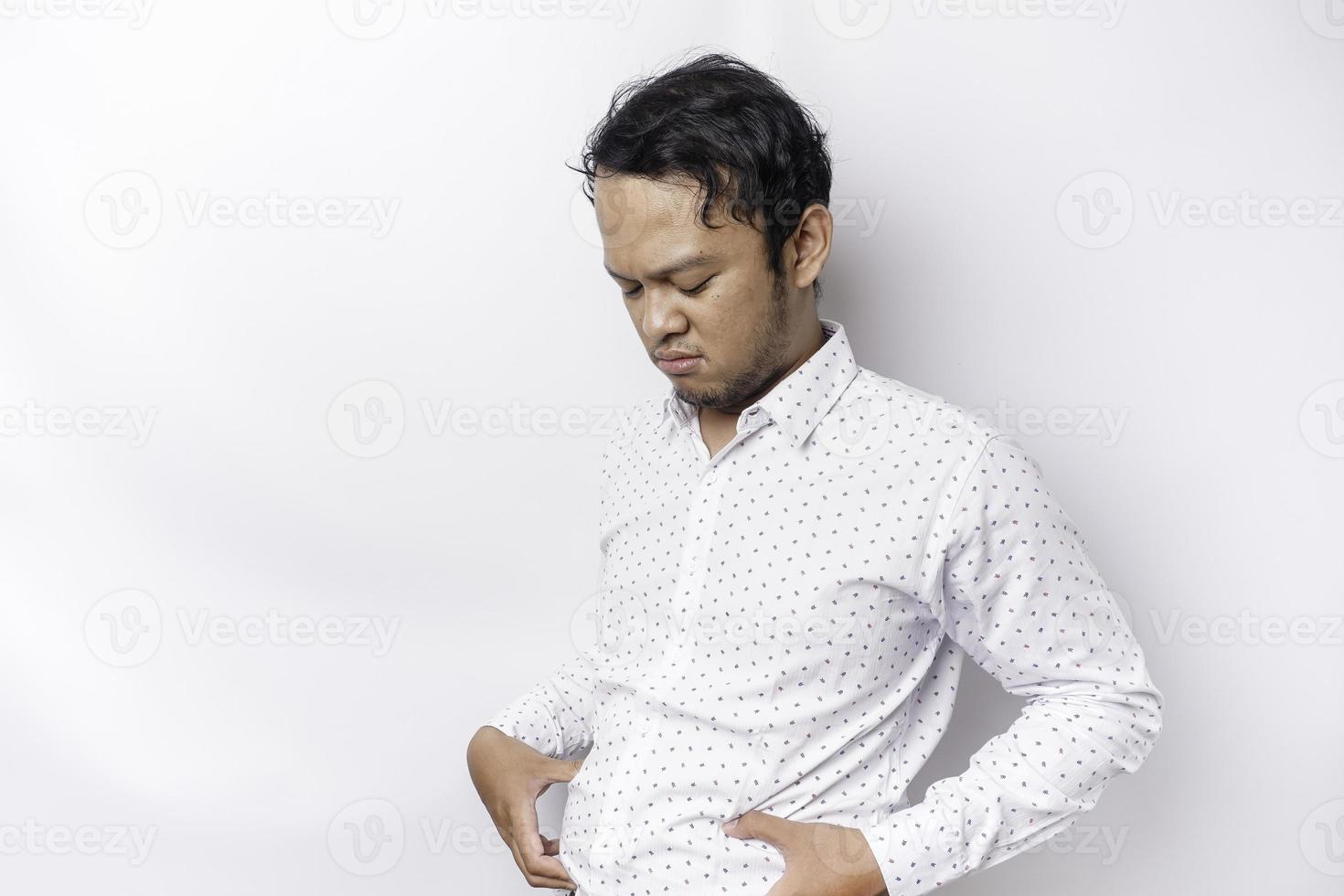 A portrait of insecure Asian fat man is holding the fat on his belly photo