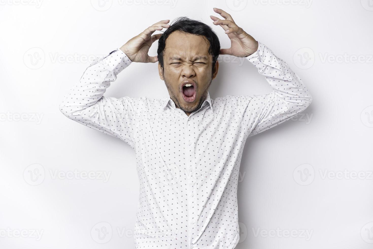 A portrait of an Asian man wearing a white shirt isolated by white background looks depressed photo