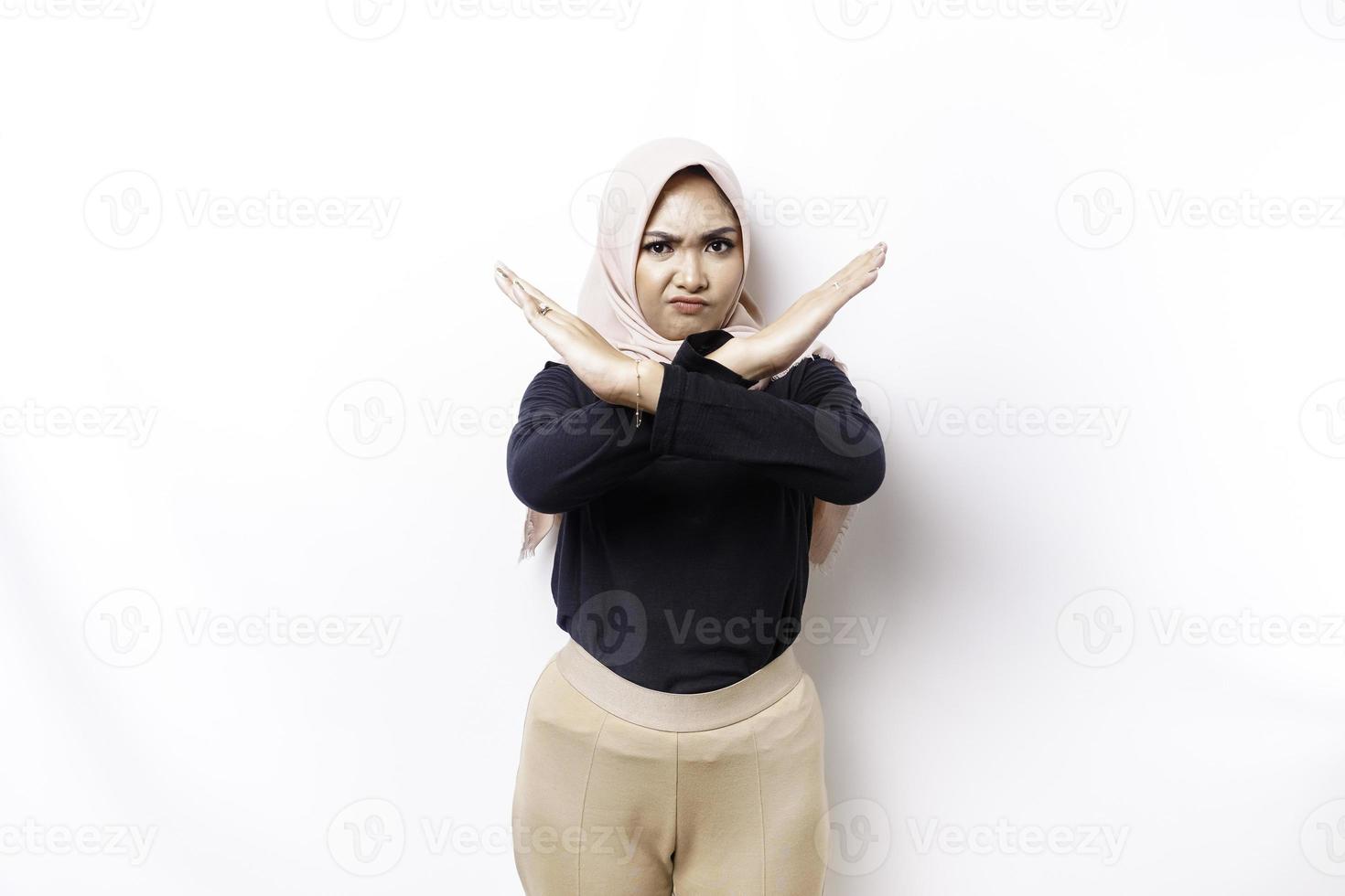Beautiful Asian Muslim woman wearing a hijab with hand gesture pose rejection or prohibition with copy space photo