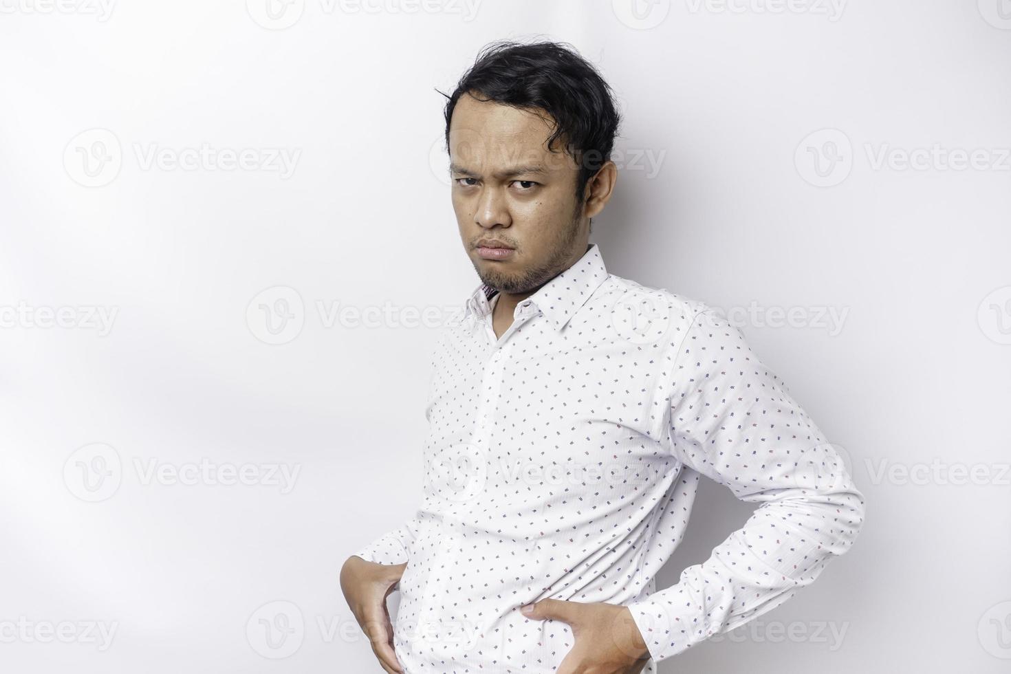 A portrait of insecure Asian fat man is holding the fat on his belly photo