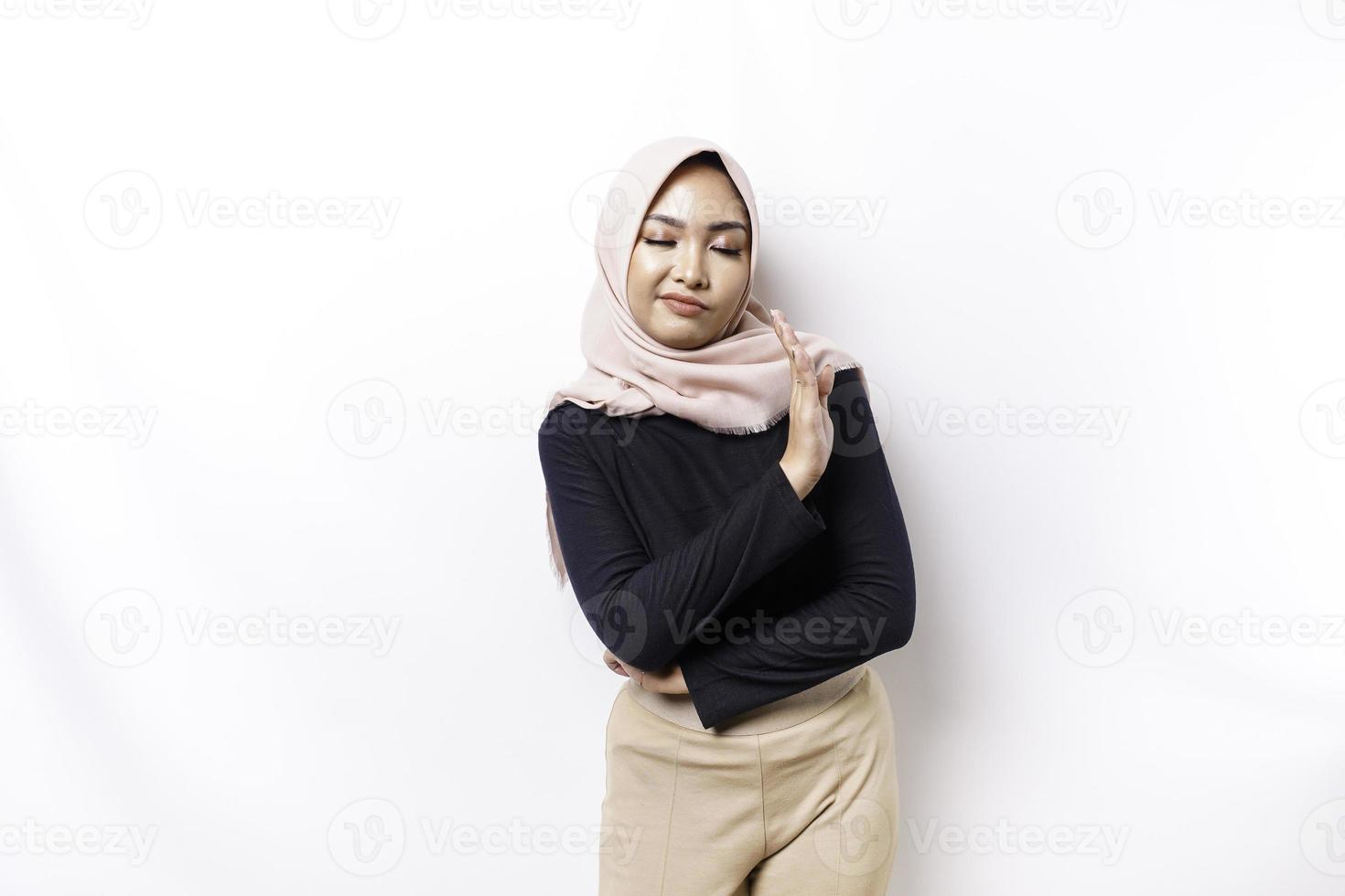 Beautiful Asian Muslim woman wearing a hijab with hand gesture pose rejection or prohibition with copy space photo