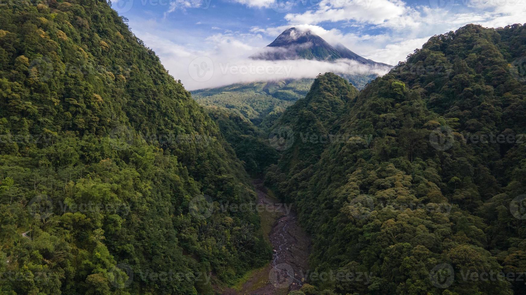 Beautiful morning view of Mount Merapi in Yogyakarta, Indonesia. Squished hills and shrouded in clouds. photo